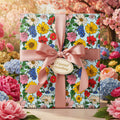 Square gift wrapped in colorful floral wrapping paper with a pink ribbon and "A special something" tag.
