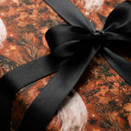Vintage Halloween wrapping paper with ghosts, autumn leaves, and a black ribbon from Wrapped Studios.