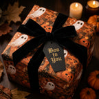 Halloween wrapping paper with ghosts and pumpkins, black velvet bow, by Wrapped Studios.
