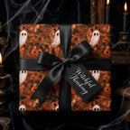 Spooky Halloween wrapping paper with ghosts and pumpkins, tied with a black bow by Wrapped Studios.