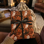 Spooky Halloween wrapping paper with ghosts and pumpkins by Wrapped Studios, tied with a dark velvet bow.