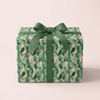 Pink and green cactus wrapping paper with a sage ribbon bow on a gift box by Wrapped Studios.