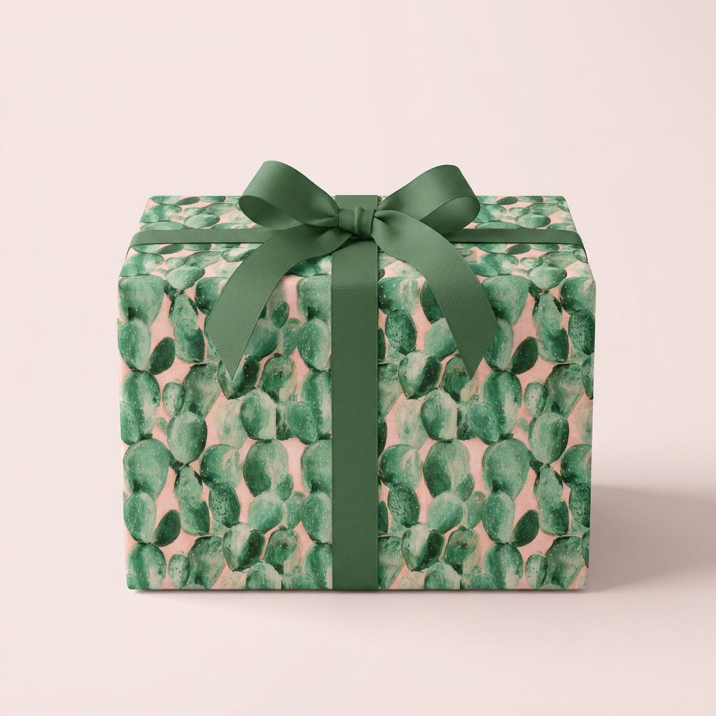 Pink and green cactus wrapping paper with a sage ribbon bow on a gift box by Wrapped Studios.