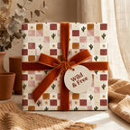 Boho cactus wrapping paper with retro checkerboard pattern and rust velvet bow by Wrapped Studios.