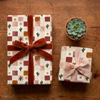 Boho cactus wrapping paper with terracotta velvet ribbon on a wood table by Wrapped Studios.