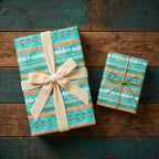 Boho Southwestern wrapping paper in teal and orange with velvet ribbon on rustic wood by Wrapped Studios.