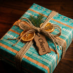 Rustic teal boho Christmas gift wrap with twine and dried oranges by Wrapped Studios.