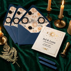 Celestial wedding invitations with navy sun and moon envelope liners on green velvet by Wrapped Studios.