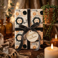 Mystical celestial wrapping paper with sun and moon design and velvet bow by Wrapped Studios.