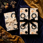 Vintage celestial sun and moon wrapping paper on gifts with velvet ribbons by Wrapped Studios.