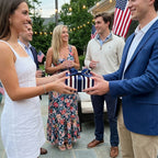 Patriotic striped wrapping paper by Wrapped Studios on a gift being exchanged at a 4th of July party.