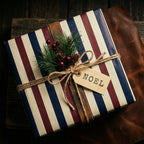Rustic striped Christmas wrapping paper by Wrapped Studios with twine, a pine sprig, and a Noel tag.