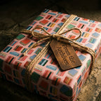 Book lover wrapping paper by Wrapped Studios on a gift tied with rustic twine and a leather tag.
