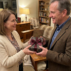 Exchanging gifts wrapped in dark floral wrapping paper with a burgundy ribbon bow.