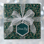 Elegant gift box with green floral wrapping paper, sheer silver ribbon, and "Dream Big" gift tag.
