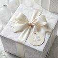 Luxury white floral wrapping paper with cream satin bow and 'With Love' tag by Wrapped Studios.