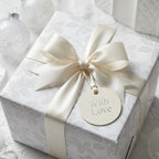 Luxury white floral wrapping paper with cream satin bow and 'With Love' tag by Wrapped Studios.