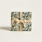 Elegant Christmas gift wrap in a vintage botanical pattern with ornaments, berries, pine, and a champagne velvet ribbon.