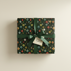 Dark floral wrapping paper on a square gift box with a satin ribbon and bow.