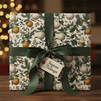 Elegant Christmas gift wrap featuring a vintage botanical pattern with gold and white ornaments, tied with a dark green satin ribbon and "Joyous Tidings" tag.