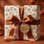 Rustic botanical Christmas wrapping paper with copper bow and Warm Wishes tag by Wrapped Studios.