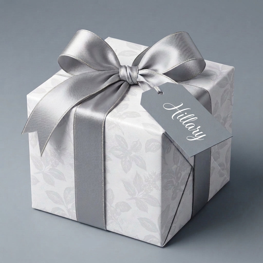 Elegant white floral wrapping paper with a silver satin bow on a gift box, by Wrapped Studios.