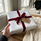Elegant white floral Christmas wrapping paper with a luxury red velvet bow by Wrapped Studios.