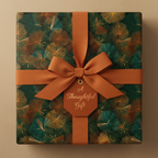 Wrapped present with green floral wrapping paper, burnt orange ribbon and tag.