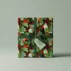 Elegant gift wrapped in floral Christmas wrapping paper with a green satin ribbon and berry accents.