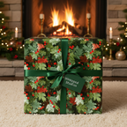 Christmas present wrapped in festive botanical wrapping paper with green ribbon by fireplace.