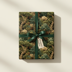 Gift box wrapped in elegant forest-themed wrapping paper with a dark green ribbon.