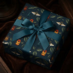 Close-up of a gift wrapped in botanical insect wrapping paper with a teal ribbon.