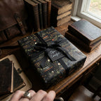 Elegant gift wrapped in bookshelf-themed wrapping paper with a black ribbon, suitable for book lovers.
