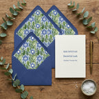 Bar Mitzvah invitation with botanical Star of David envelope liners by Wrapped Studios on a wood table.