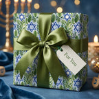 Hanukkah wrapping paper with blue Star of David and green leaves, featuring an olive bow by Wrapped Studios.