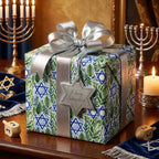 Luxury Hanukkah wrapping paper with blue stars and green leaves, tied with a silver bow by Wrapped Studios.