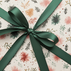 Elegant botanical wrapping paper with a dark green ribbon, perfect for Christmas or winter gifts.