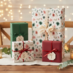 Elegant Christmas gift wrap featuring a white floral and greenery pattern, forest green and burgundy solid paper, with coordinating ribbons and personalized tags, all set on a rustic wooden table with soft, twinkling lights in the background.