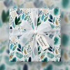 Modern botanical wrapping paper with a teal and green leaf pattern, tied with a sheer white ribbon and "Wrapped Studios" gift tag.