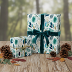 Winter botanical wrapping paper gift box with teal velvet ribbon and pinecones on a rustic wooden table, perfect for luxury Christmas gifts.