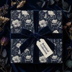 Elegant floral wrapping paper in navy with velvet ribbon bow, perfect for birthday gift wrap or botanical themed gifts.