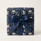 Elegant gift wrapped in navy floral wrapping paper with a dark blue satin bow.