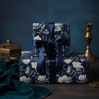 Stacked gifts wrapped in navy floral wrapping paper with a navy ribbon.