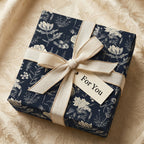 Elegant navy floral wrapping paper on a square gift box with a beige ribbon and "For You" tag.