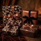 Luxury black and copper leaf wrapping paper with elegant satin ribbons on gift boxes by Wrapped Studios.