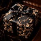 Luxury black and gold floral wrapping paper with satin ribbon and gift tag by Wrapped Studios.