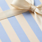 Blue and cream striped wrapping paper with an elegant cream satin bow by Wrapped Studios.
