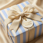 Luxury blue and cream striped wrapping paper with a velvet bow and gift tag by Wrapped Studios.