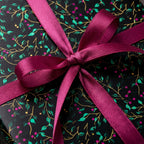 Black floral wrapping paper with magenta ribbon from Wrapped Studios.