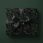 Elegant floral wrapping paper with gold accents and black satin bow. Wrapped Studios.